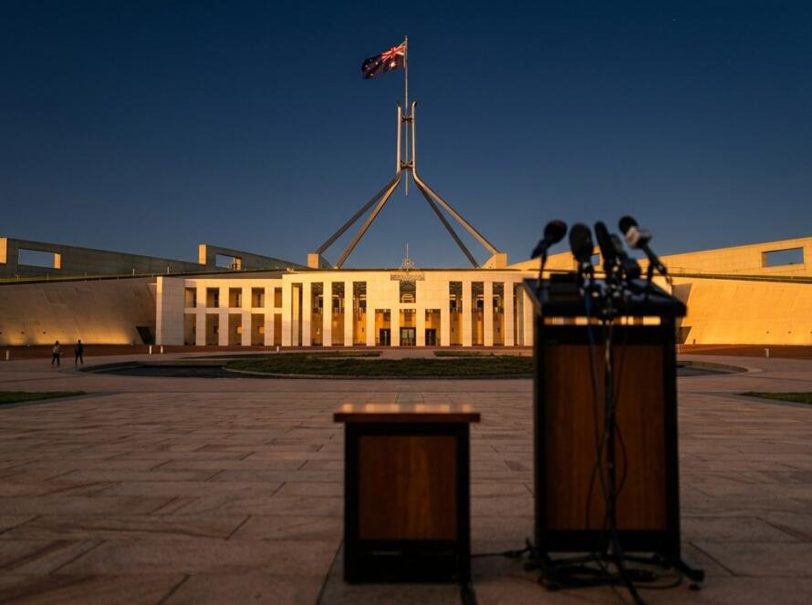 Parliament House, Canberra, at golden hour with a press lectern in the foreground
